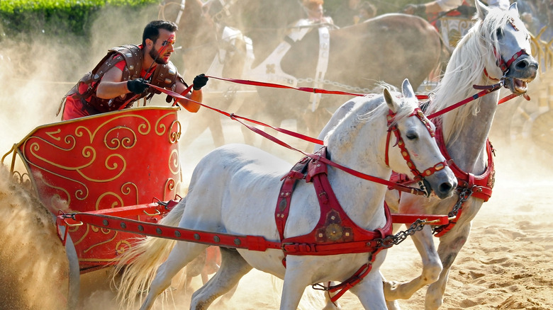 Men riding horses in chariot