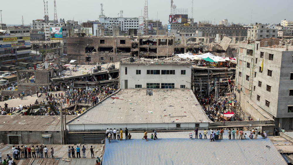 Rana Plaza with people standing amongst debris