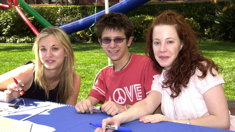 Kaley Cuoco, Amy Davidson, and Martin Spanjers smiling and signing autographs