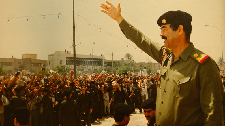 saddam hussein salutes crowd in military uniform