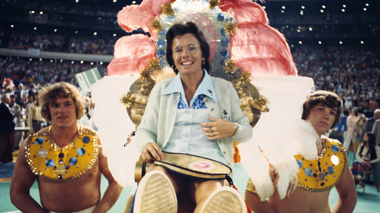 Billie Jean King being carried in by male models