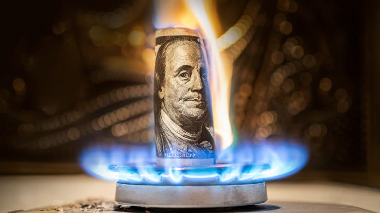 hundred-dollar bill burning gas stove