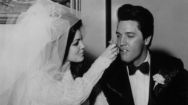 Priscilla Presley feeding Elvis Presley wedding cake
