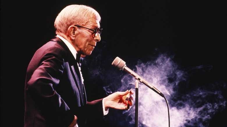 older George Burns before microphone