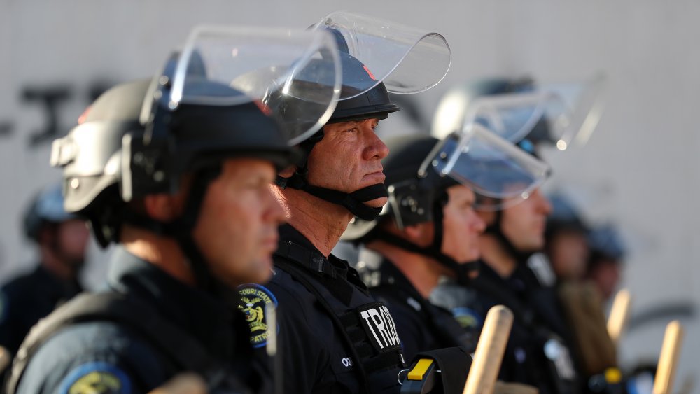 Police with face shields and batons square off against protesters