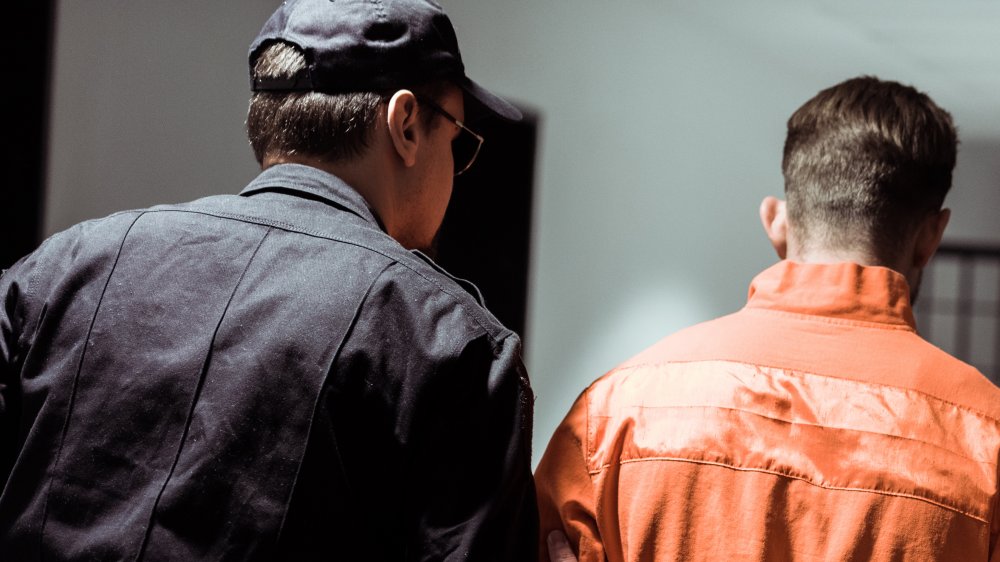 A prison officer escorting an inmate