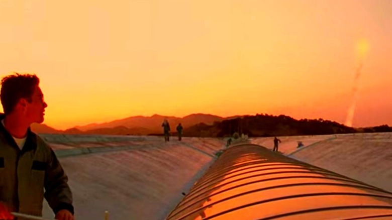 Workers on a roof watching a rocket launch 