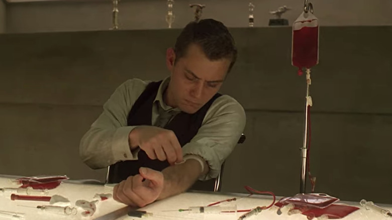 Eugene (Jude Law) in Gattaca extracting his own blood