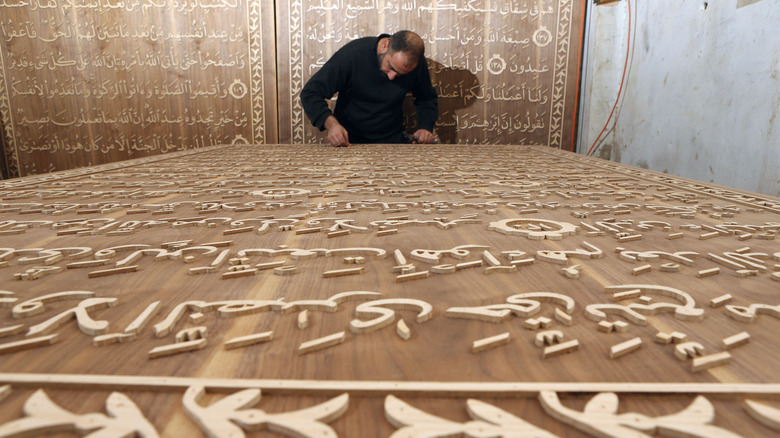 Syrian refugee artist carving Quran