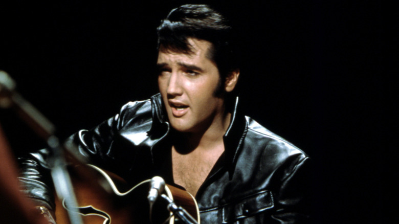 Elvis Presley playing guitar on stage