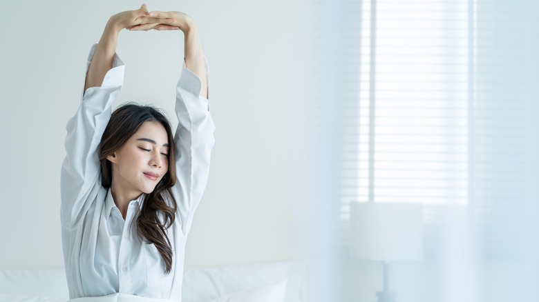 woman waking up and stretching