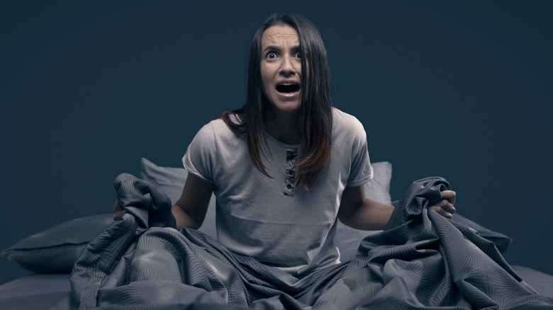 woman screaming in bed after a nightmare