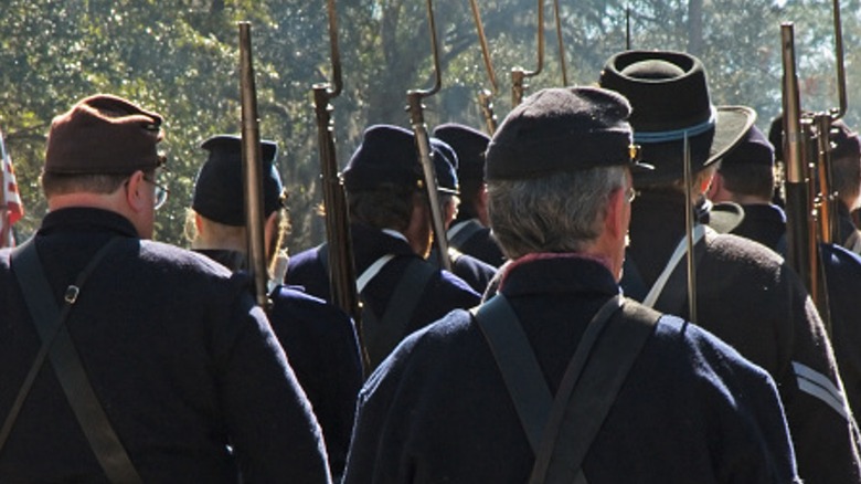 Civil War reenactors marching back of heads