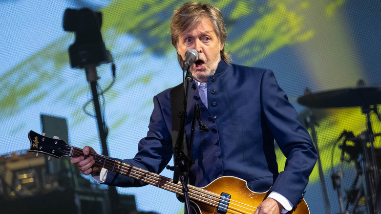 Paul McCartney performing on stage with guitar