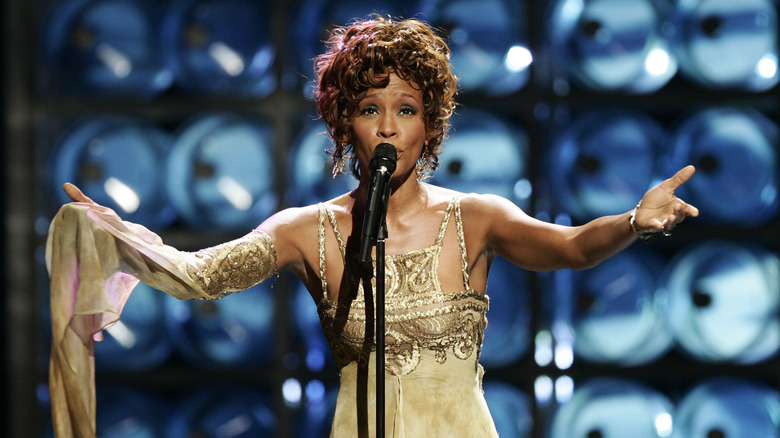 Whitney Houston singing arms out