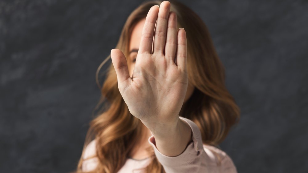 Woman with hand in front of face