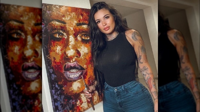 Tatu Baby posing with her painting