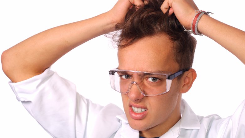 scientist holding hair safety glasses