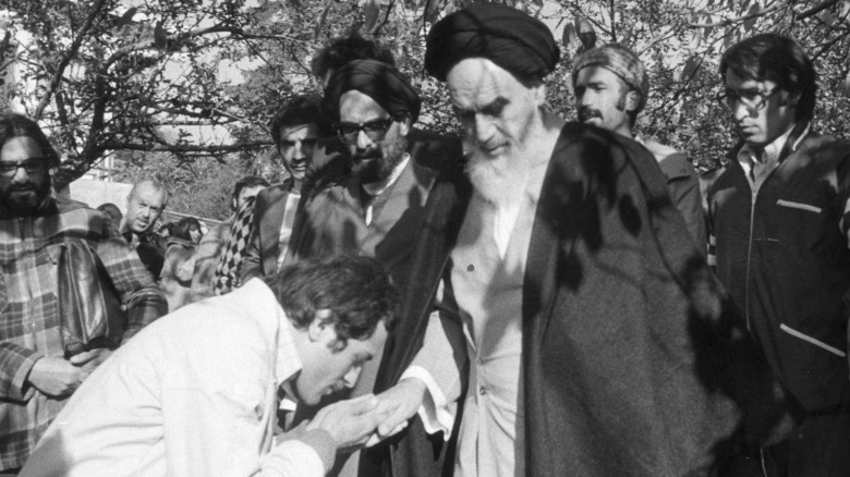 Khomeini holding hand of follower