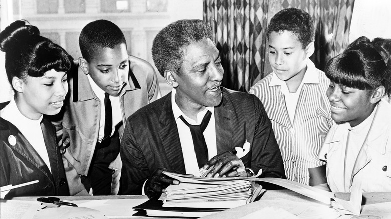 Rustin sat papers children around him