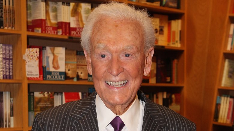 Bob Barker smiling in front of bookshelf