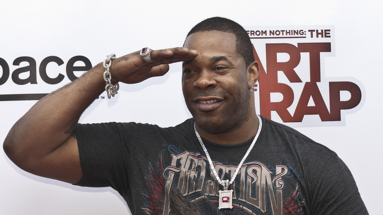 Busta Rhymes shielding his eyes