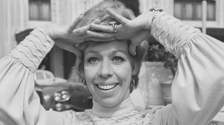 Carol Burnett hands on head smiling