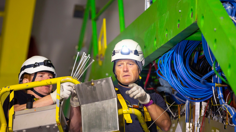 workers working on large hadron collider