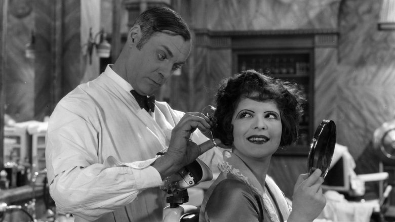 A man cutting Clara Bow's hair