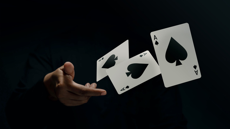 Magician hurling cards