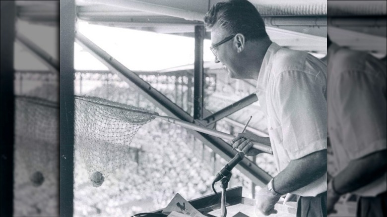 Harry Caray with a net in the broadcast booth