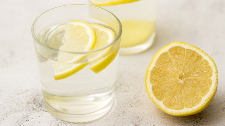 Lemons next to glasses of water with lemons