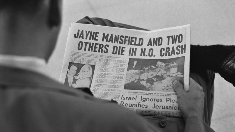 Man reading newspaper about Jayne Mansfield's death