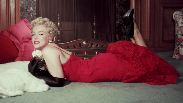 Marilyn Monroe posing while laying on floor