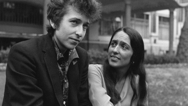 Joan Baez sitting outside with Bob Dylan