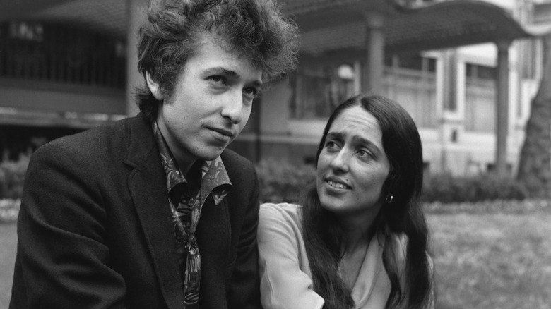 Joan Baez sitting outside with Bob Dylan