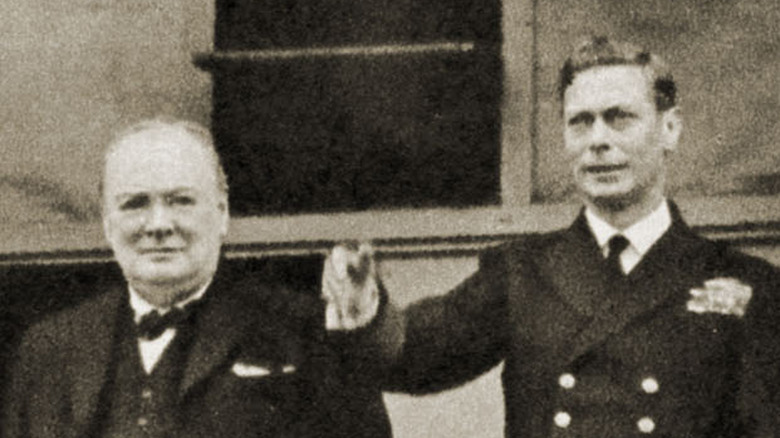 Winston Churchill and George VI greet the crowd from Buckingham Palace