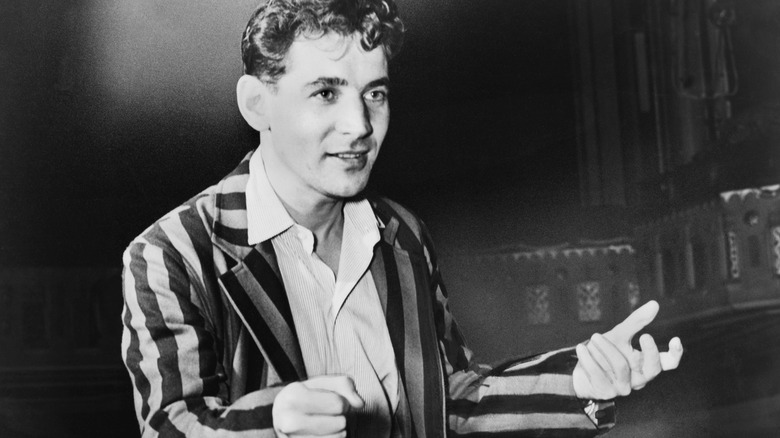 Leonard Bernstein smiling in a striped jacket