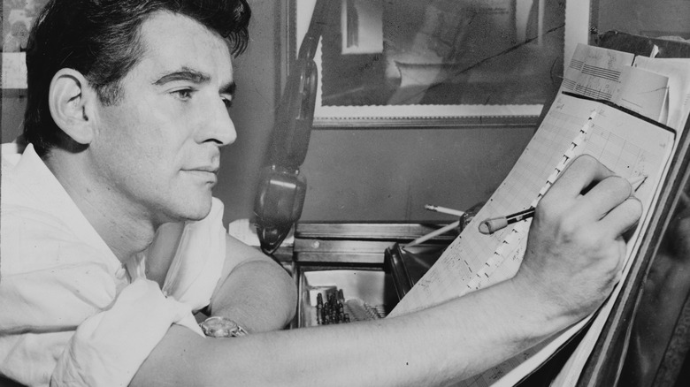 Leonard Bernstein making notes at desk