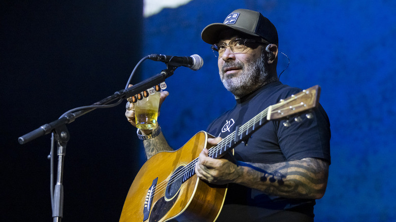 Aaron Lewis playing guitar holding drink