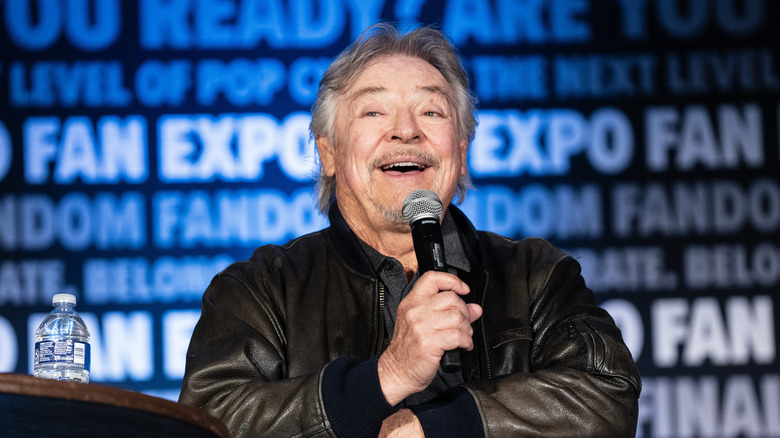 Frank Welker holding microphone smiling 