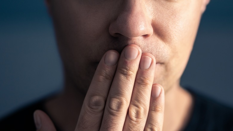 Man holding hand over mouth