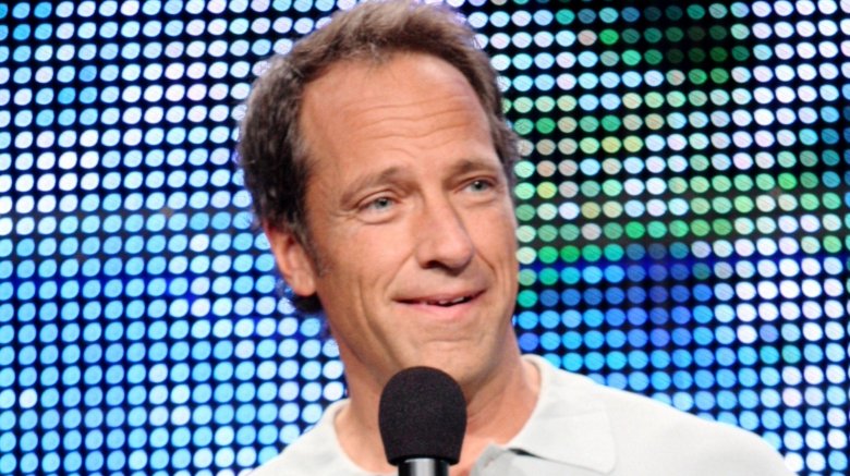 mike rowe mic blue dot background smiling