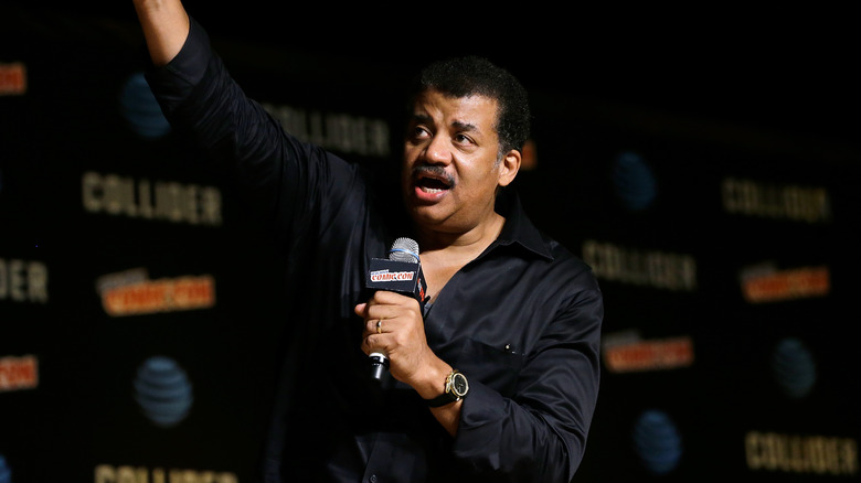 Neil deGrasse Tyson raising arm