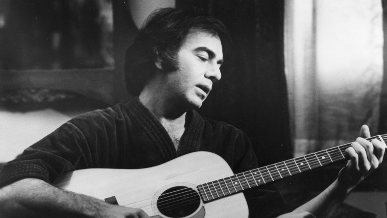 Young Neil Diamond sat playing guitar