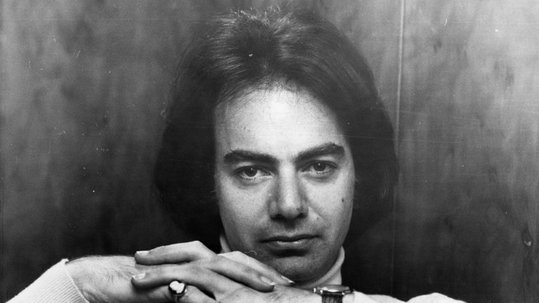 Young Neil Diamond staring forward hands clasped