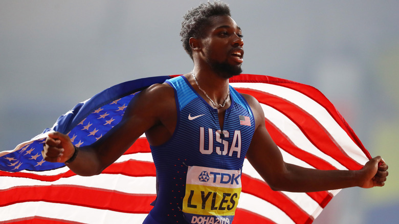 Noah Lyles carrying US flag