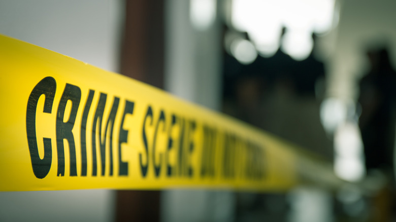 crime scene image with figures in the background