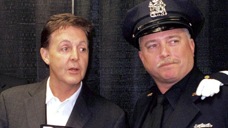 Paul McCartney and a NYPD officer looking side