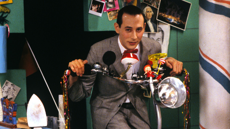 Paul Reubens as Pee-wee Herman on a scooter